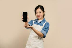 Asian female waitress portrait, isolated on light brown background photo