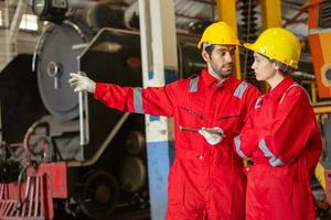 Engineer with worker talking together at factory photo