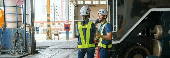 ingeniero con trabajador hablando juntos a fábrica foto