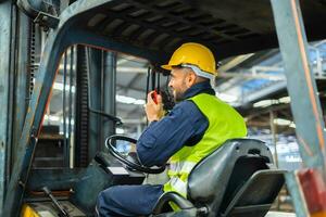 Forklift driver talking on radio for professional cargo shipping communication photo