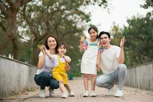 joven asiático familia en el parque foto