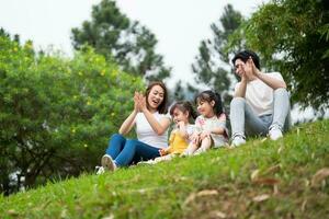 joven asiático familia en el parque foto