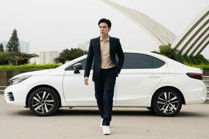 Young Asian business man with car photo