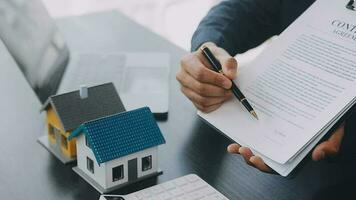 fastighetsmäklare levererar ett prov av ett modellhus till kunden, hypotekslåneavtal gör leasing och köp och sälj hus och kontrakt hemförsäkring hypotekslån koncept video