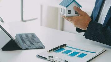 l'agent de courtage immobilier livre un échantillon d'une maison modèle au client, un contrat de prêt hypothécaire fait un bail et achète et vend une maison et contracte un concept de prêt hypothécaire d'assurance habitation video