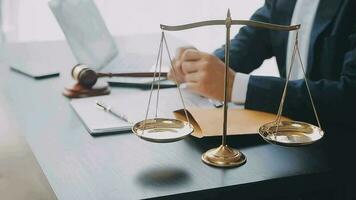 Justice and law concept.Male judge in a courtroom with the gavel, working with, computer and docking keyboard, eyeglasses, on table in morning light video