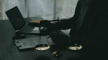 Justice and law concept.Male judge in a courtroom with the gavel, working with, computer and docking keyboard, eyeglasses, on table in morning light video