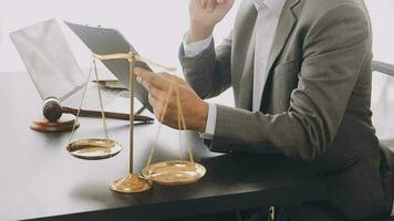 Justice and law concept.Male judge in a courtroom with the gavel, working with, computer and docking keyboard, eyeglasses, on table in morning light video