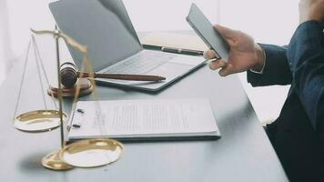 Justice and law concept.Male judge in a courtroom with the gavel, working with, computer and docking keyboard, eyeglasses, on table in morning light video