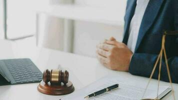 Justice and law concept.Male judge in a courtroom with the gavel, working with, computer and docking keyboard, eyeglasses, on table in morning light video