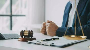 Justice and law concept.Male judge in a courtroom with the gavel, working with, computer and docking keyboard, eyeglasses, on table in morning light video