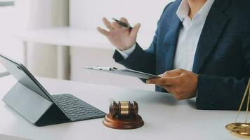 Justice and law concept.Male judge in a courtroom with the gavel, working with, computer and docking keyboard, eyeglasses, on table in morning light video