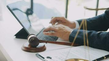 Justice and law concept.Male judge in a courtroom with the gavel, working with, computer and docking keyboard, eyeglasses, on table in morning light video