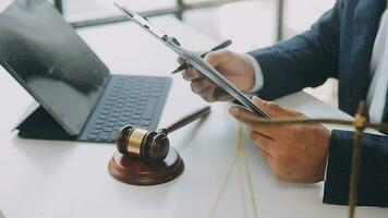 Justice and law concept.Male judge in a courtroom with the gavel, working with, computer and docking keyboard, eyeglasses, on table in morning light video