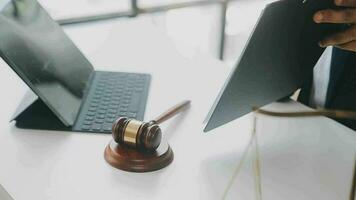 Justice and law concept.Male judge in a courtroom with the gavel, working with, computer and docking keyboard, eyeglasses, on table in morning light video