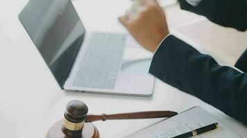 Justice and law concept.Male judge in a courtroom with the gavel, working with, computer and docking keyboard, eyeglasses, on table in morning light video