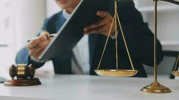Justice and law concept.Male judge in a courtroom with the gavel, working with, computer and docking keyboard, eyeglasses, on table in morning light video