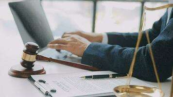 Justice and law concept.Male judge in a courtroom with the gavel, working with, computer and docking keyboard, eyeglasses, on table in morning light video