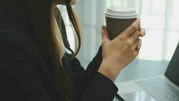 el retrato de una joven mujer asiática independiente está trabajando en su trabajo en una tableta de computadora en una oficina moderna. hacer un informe de análisis contable datos de inversión inmobiliaria, concepto de sistemas financieros y fiscales. video