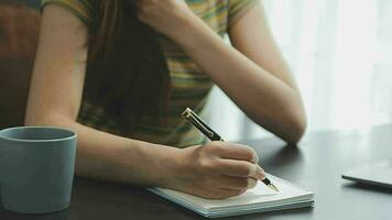 portrait d'une jeune femme asiatique pigiste à la main travaille son travail sur une tablette informatique dans un bureau moderne. faire un rapport d'analyse comptable sur les données d'investissement immobilier, le concept de systèmes financiers et fiscaux. video