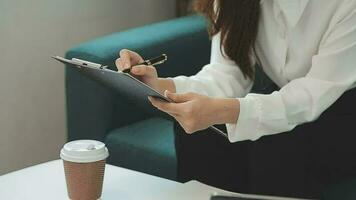 contento asiatico adolescente ragazza Tenere tampone computer aggeggio utilizzando digitale tavoletta tecnologia seduta su il divano a casa. sorridente giovane donna utilizzando app, shopping in linea, lettura notizia, navigazione Internet su divano video