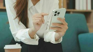 content asiatique adolescent fille en portant tampon ordinateur gadget en utilisant numérique tablette La technologie séance sur le canapé à maison. souriant Jeune femme en utilisant applications, achats en ligne, en train de lire nouvelles, navigation l'Internet sur canapé video