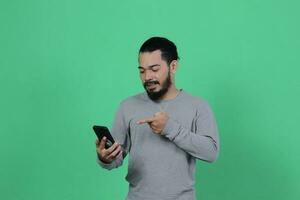 asian man expression while using smartphone photo