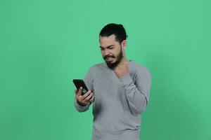 asiático hombre expresión mientras utilizando teléfono inteligente foto