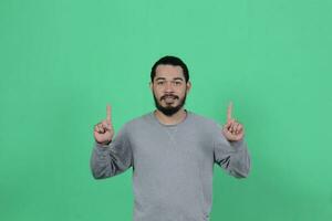 bearded asian man poses wearing a gray shirt against a green background photo