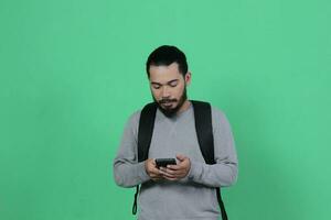 bearded asian student expression using smartphone photo