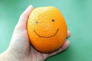 Smiling orange on a green background photo