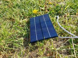 Solar panel for charging a smartphone on the grass photo