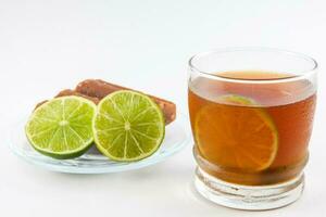 Cold sugarcane water with lemon on white background. Aguapanela photo