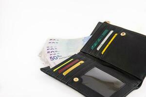 Black wallet filled with fifty thousand Colombian pesos bills and cards. Finance concept. Economy concept. Payment concept. photo