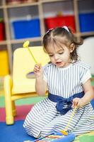 Sweet little girl learning to play instruments. photo