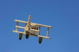 Wooden Plane flying with blue sky - Going away photo