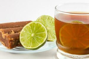 Cold sugarcane water with lemon on white background. Aguapanela photo