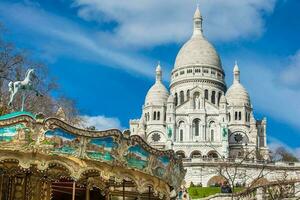 carrusel y el histórico sacre coeur basílica construido en el Dieciocho siglo a el Montmartre colina en París Francia foto