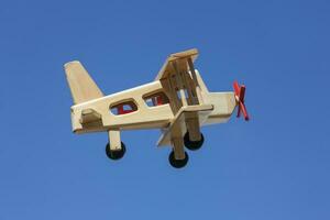 Wooden Plane flying with blue sky - Side view photo