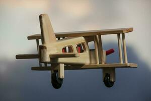 Wooden plane flying under the stormy sky -  Going away photo