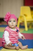 Sweet little baby girl learning to play instruments. photo