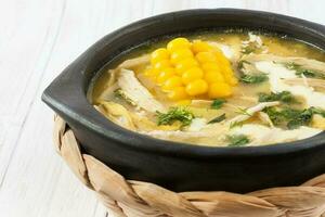 Traditional Colombian ajiaco served on black ceramic dish photo