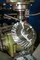 Working milling machine creating a gear photo