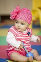 Sweet little baby girl learning to play instruments. photo