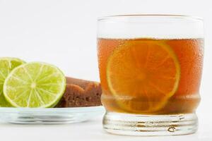 Cold sugarcane water with lemon on white background. Aguapanela photo