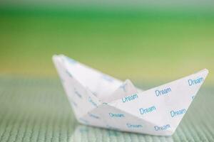 Follow your dreams concept. Origami boat photo