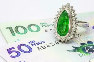 Colombian Emerald Ring and 2016 issued bills. Luxury concept. Wealth concept photo