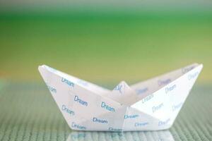 Follow your dreams concept. Origami boat photo
