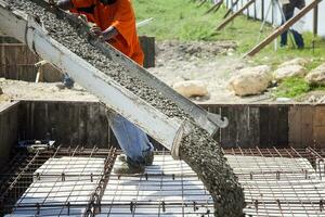 Man pouring concrete from a mixer truck photo