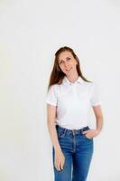 un linda y sonriente niña en un blanco camiseta sonrisas alegremente y expresa positivo emociones en un blanco antecedentes. foto